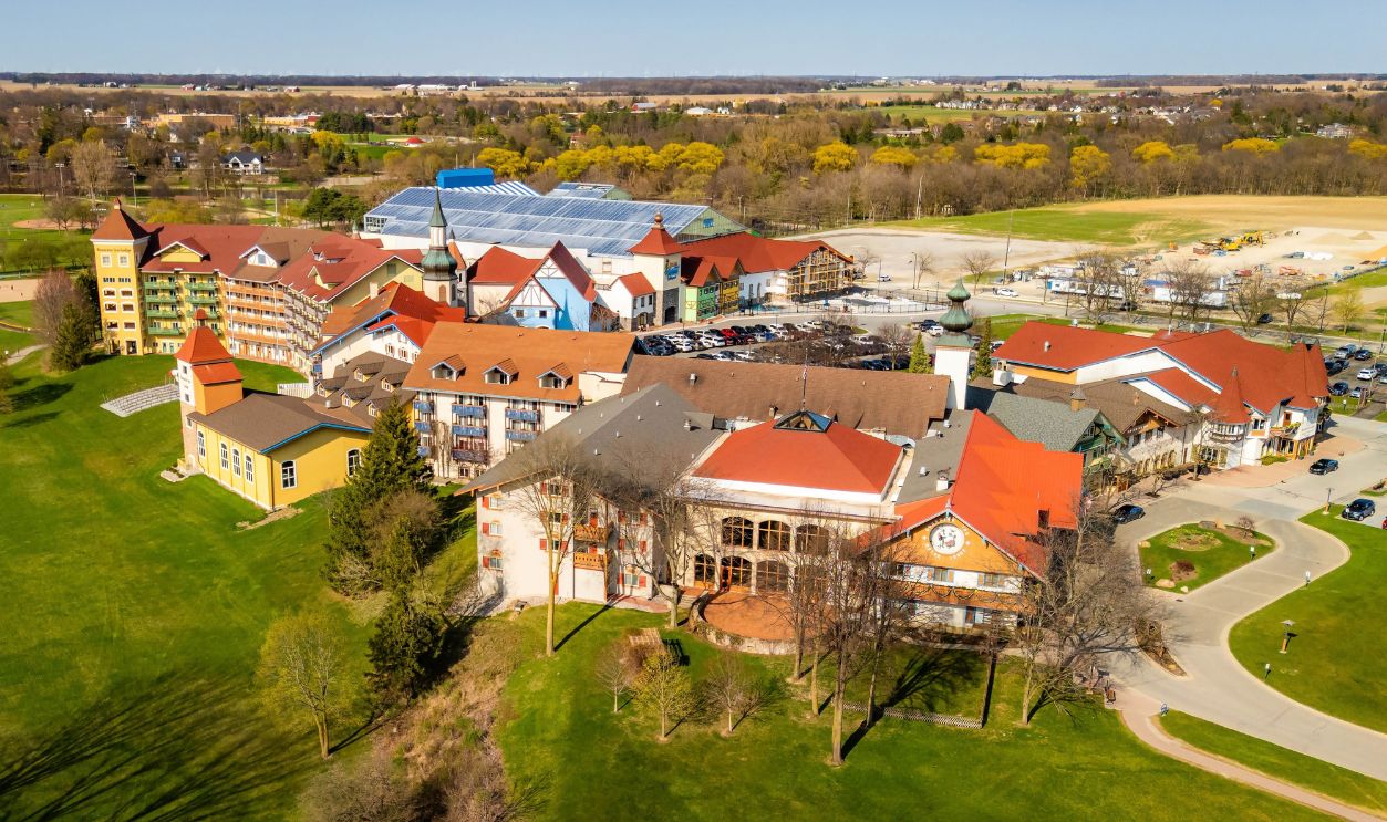 Frankenmuth, MI, USA - 04-22-2025: Aerial photo of hotels in Frankenmuth Michigan on a sunny day showing Bavarian-style rooftops, streets, and surrounding landscape.