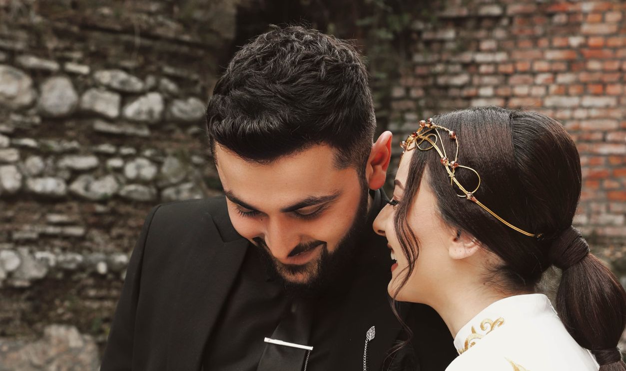 Charming bride and groom share a joyful moment during their outdoor wedding ceremony.