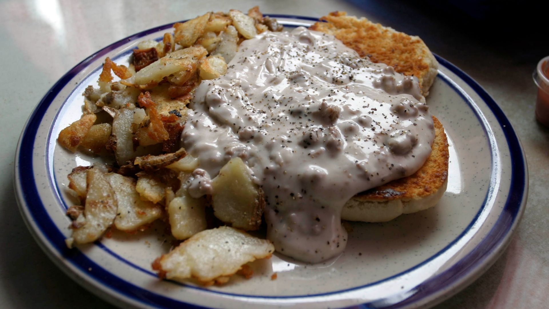 Picture of Biscuits and gravy, with a side order of home fries.  Image taken by the author at Daddypop's Tumble Inn Diner in Claremont, NH, USA.