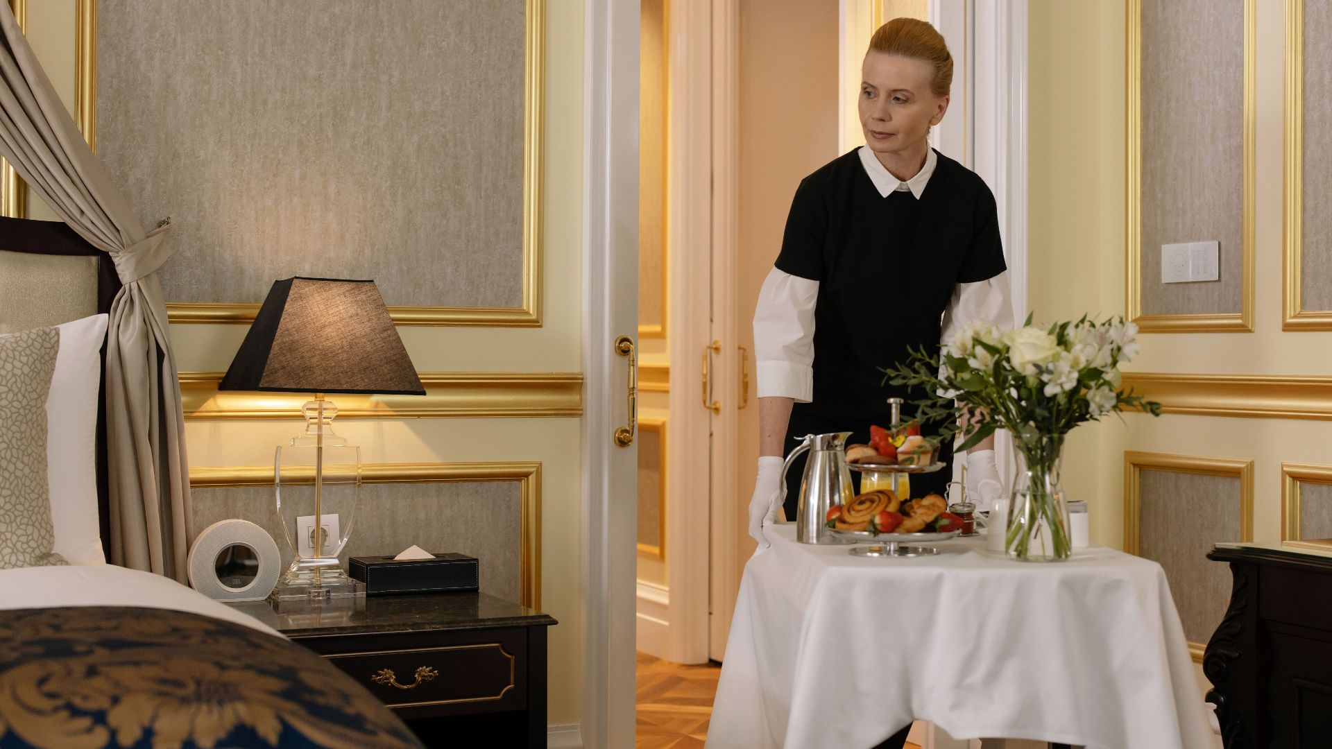 Chambermaid delivering luxury room service breakfast to a stylish hotel room, exuding comfort and hospitality.