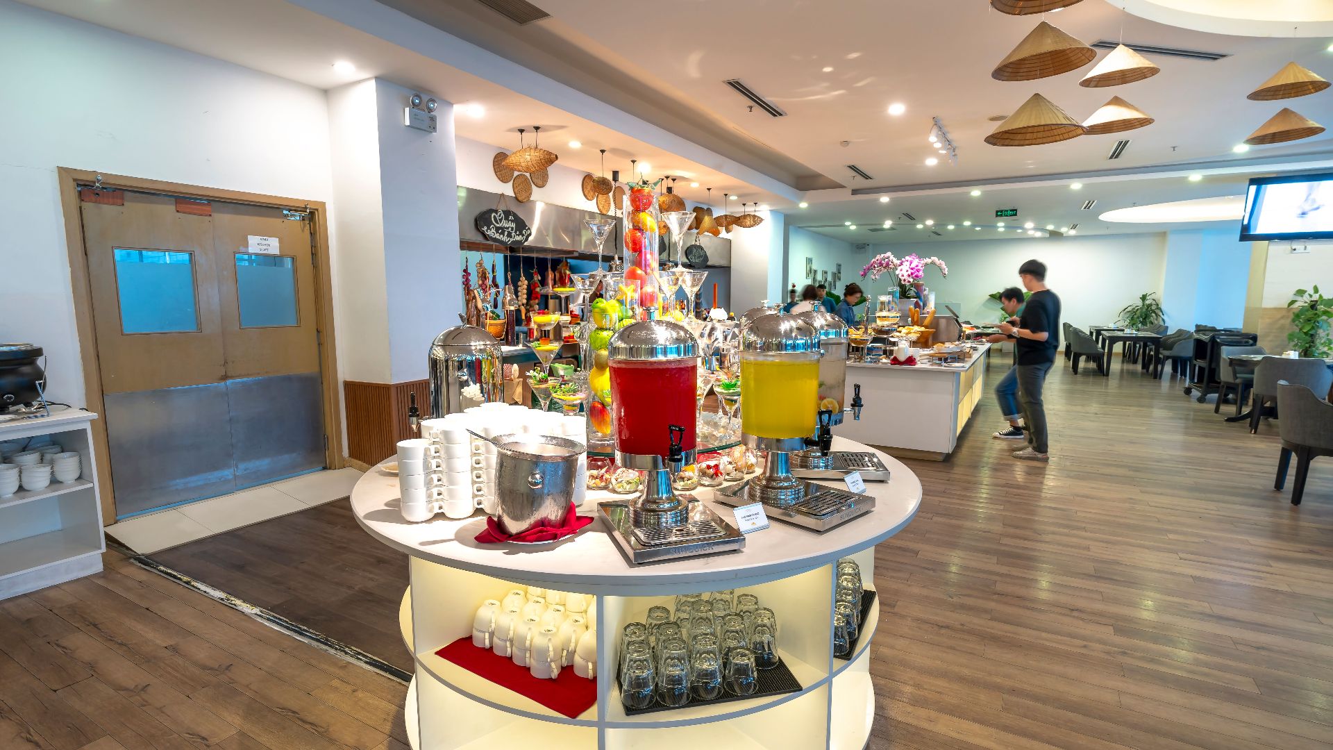Spacious hotel buffet area with a variety of drinks and seating arrangements.
