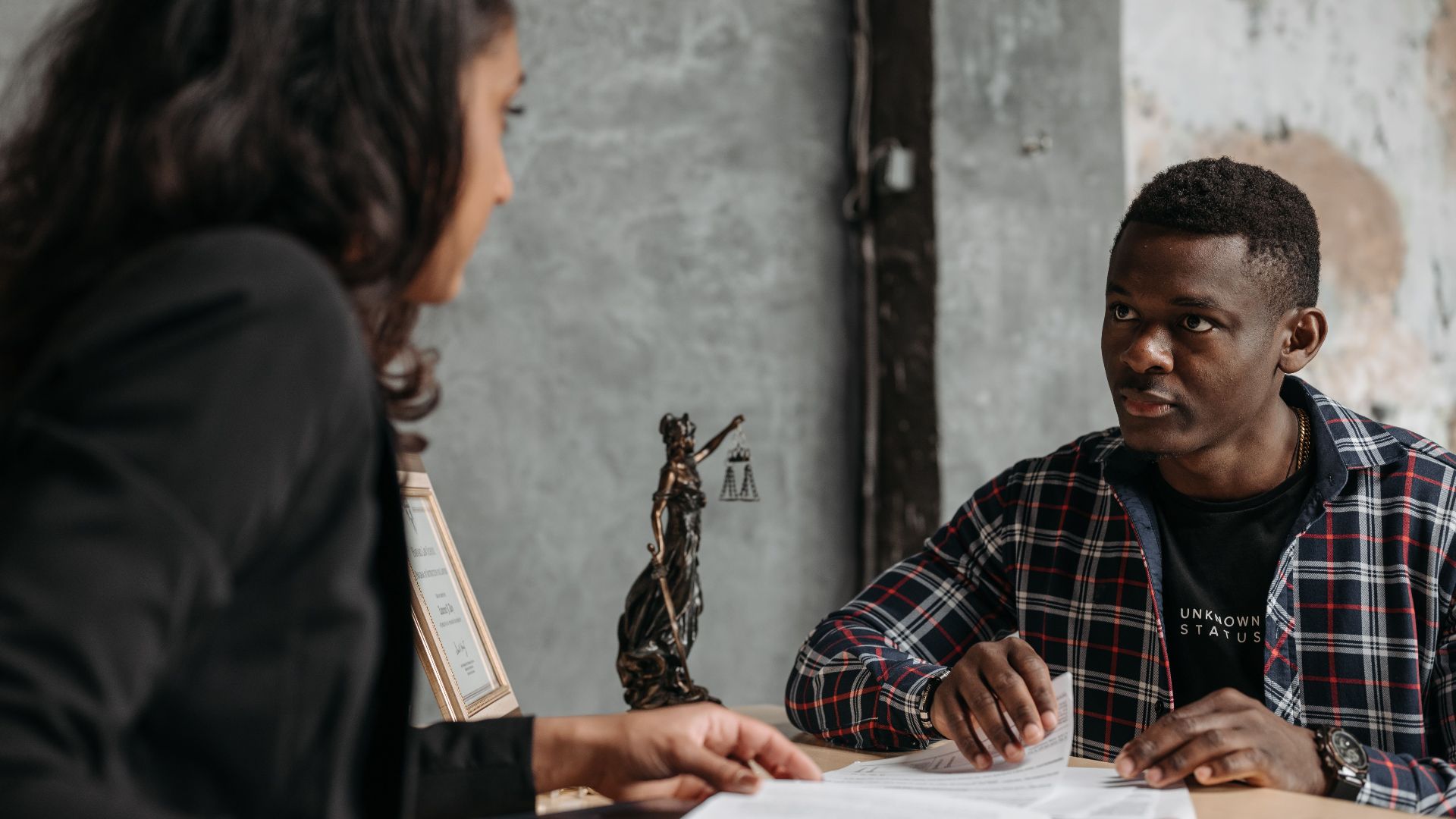 Business meeting between a lawyer and client in a professional office setting.