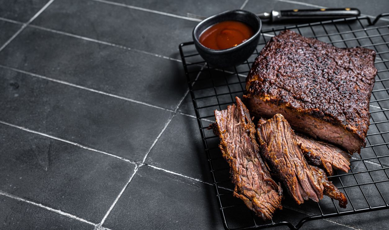 Chopped Beef Brisket barbecue, Traditional meat rubbed with spices and smoked in a Texas smoker. Black background. Top view. Copy space.