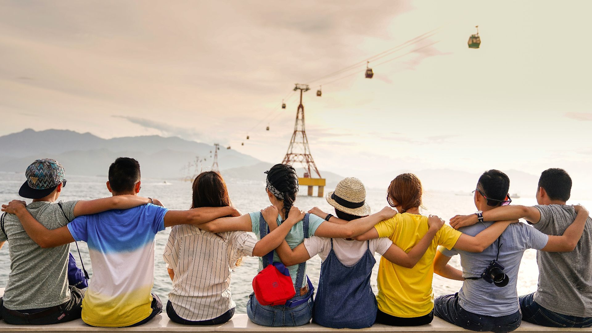 people holding shoulders sitting on wall