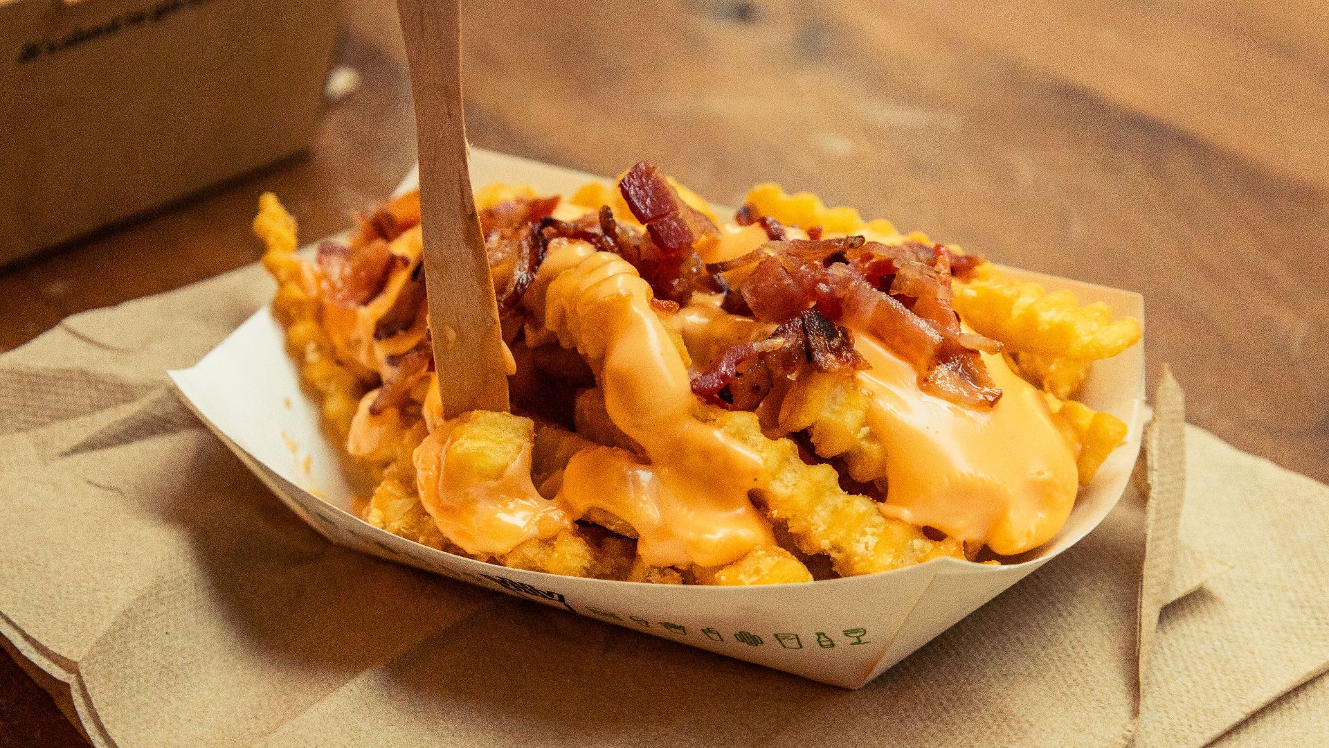 Indulge in crispy crinkle-cut fries topped with gooey cheese sauce and savory bacon.