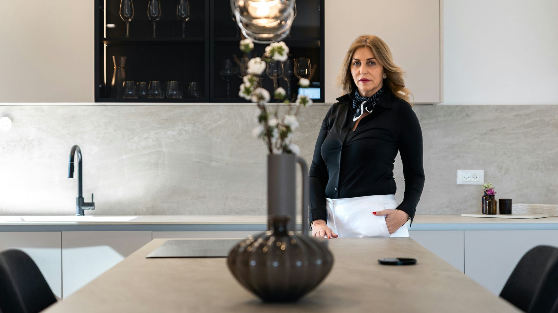 Woman standing in a modern kitchen with island