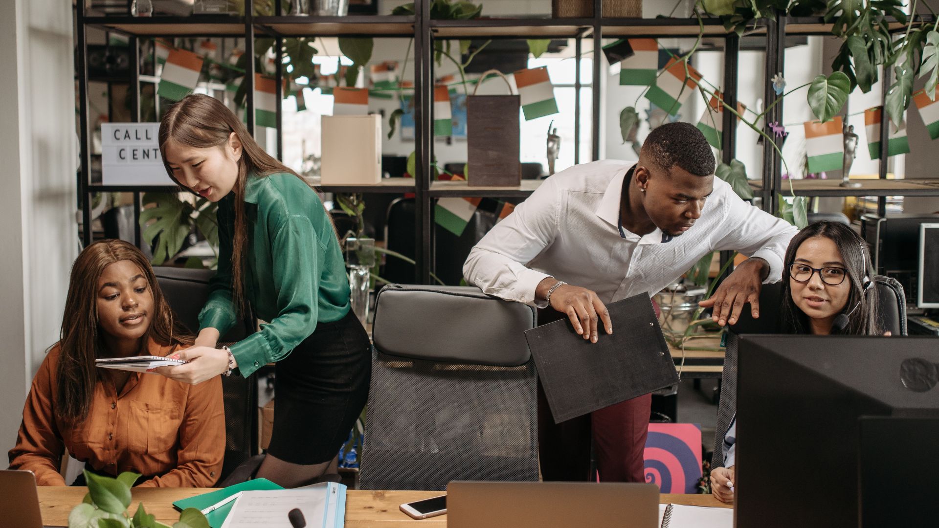A diverse group of co-workers engaged in communication and teamwork in a call center environment.