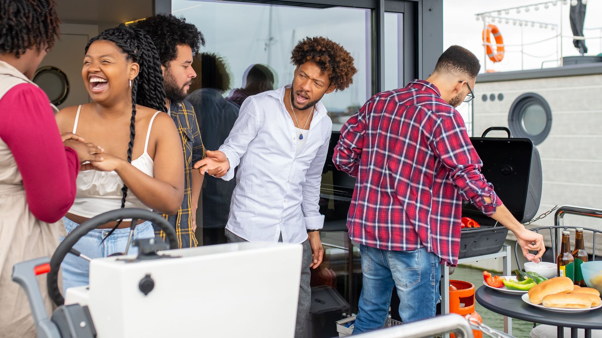 A lively group of friends enjoying a barbecue outdoors on a stylish patio.