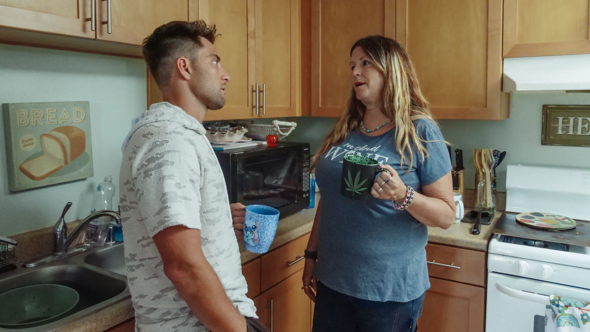 Mother and son enjoying a casual conversation in the kitchen over coffee.