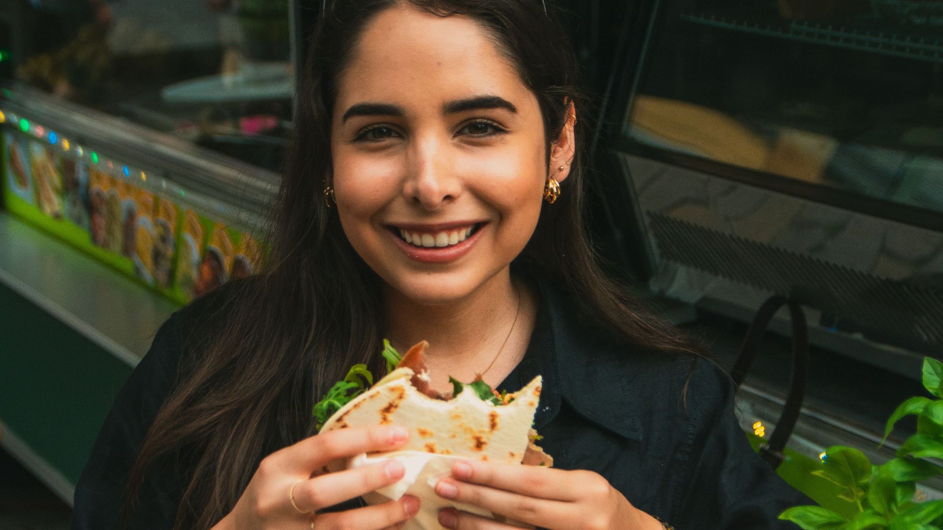 A cheerful woman savors a piadina at a Berlin food truck, capturing the lively street vibe.
