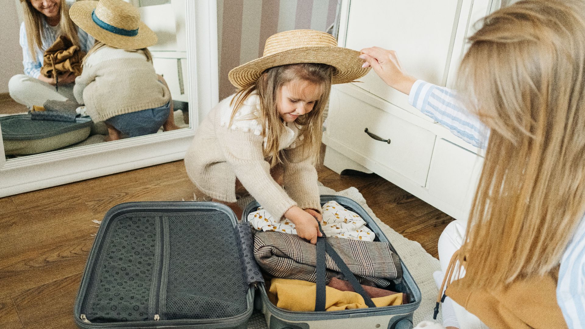 A mother and daughter pack a suitcase for a summer vacation, creating joyful memories.