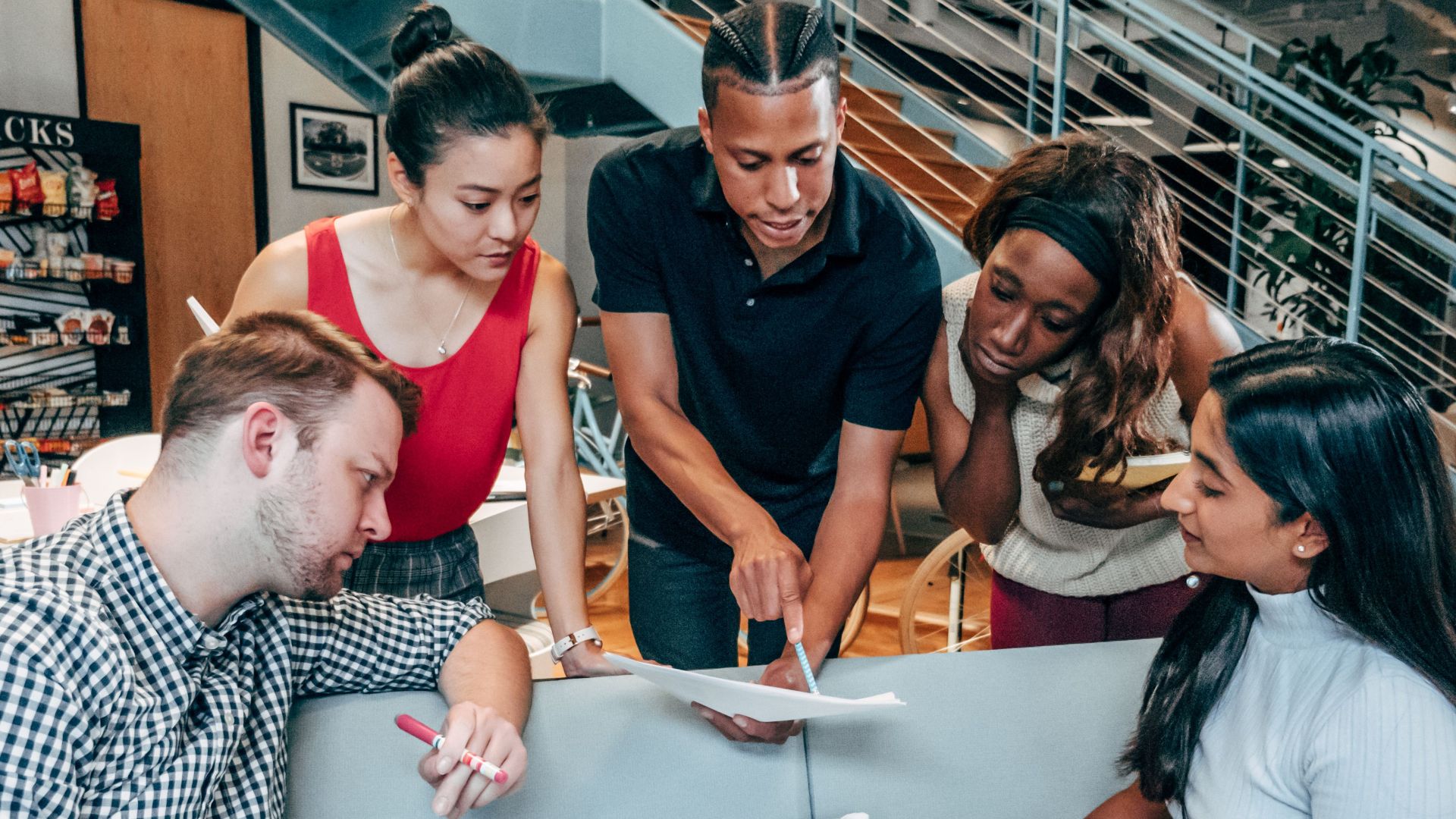 Group of diverse coworkers brainstorming and collaborating in a modern office setting.