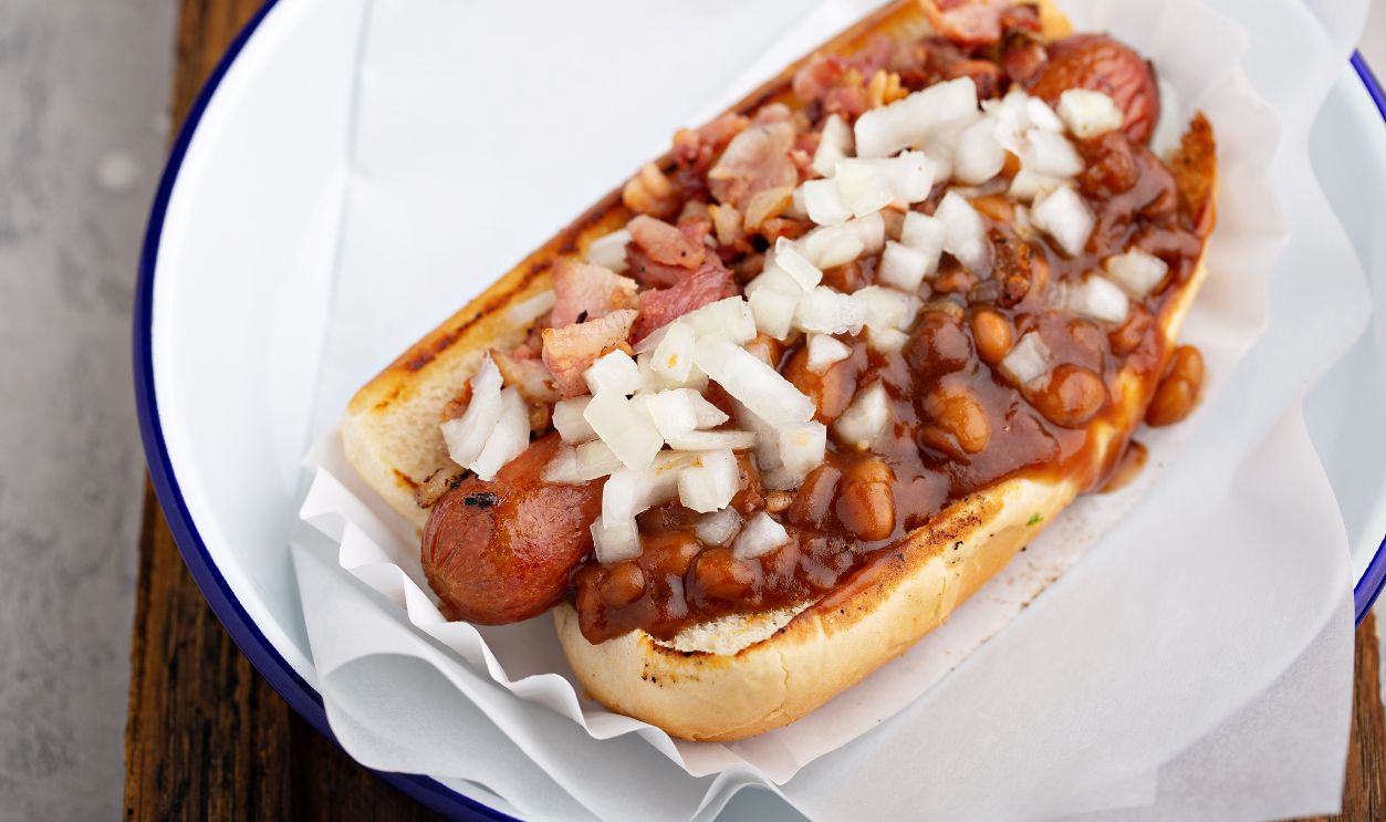 Chili hot dog with beans, bacon and onion