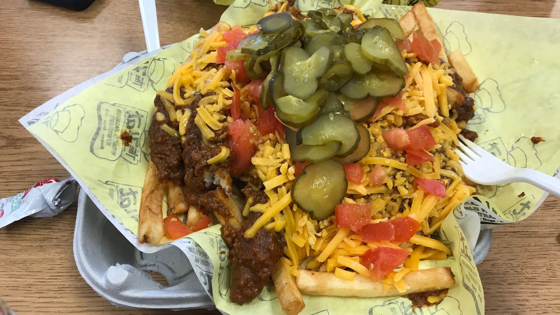 Chili cheese fries with tomato and pickles from The Hat