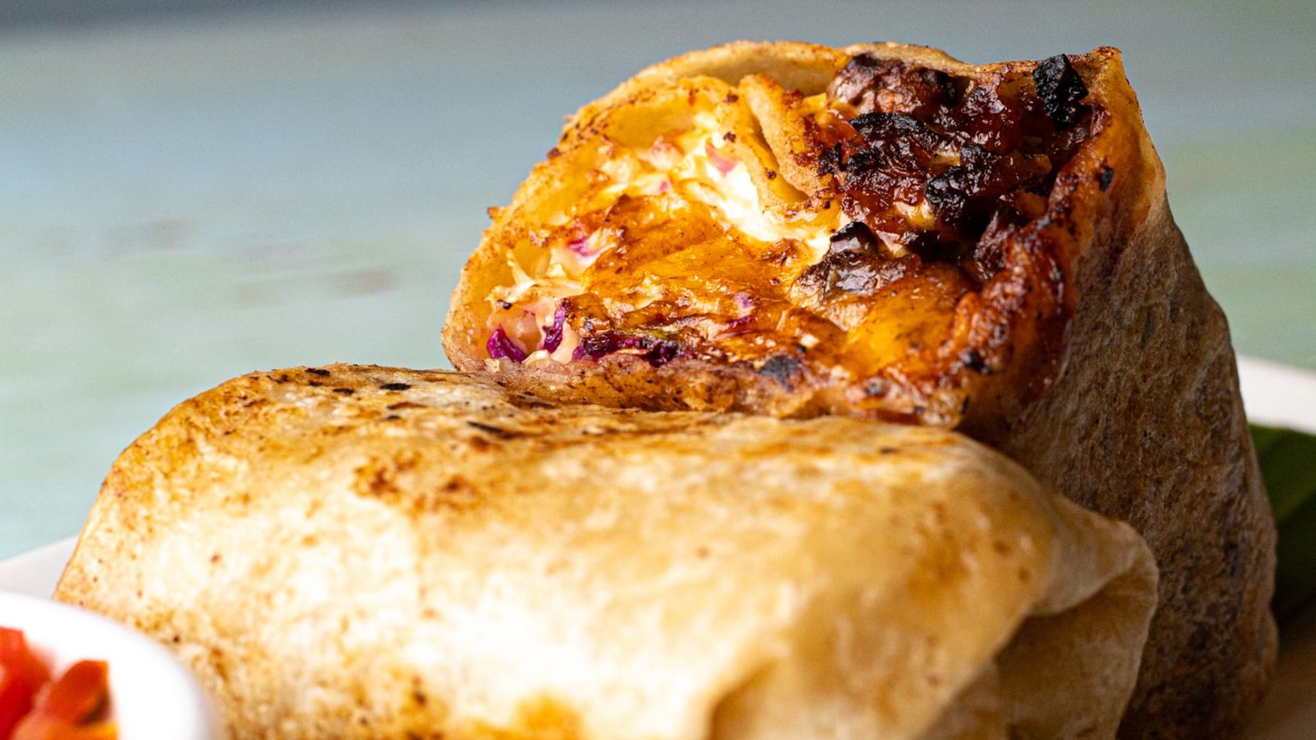 Close-up of a tasty grilled burrito with crispy, savory filling.