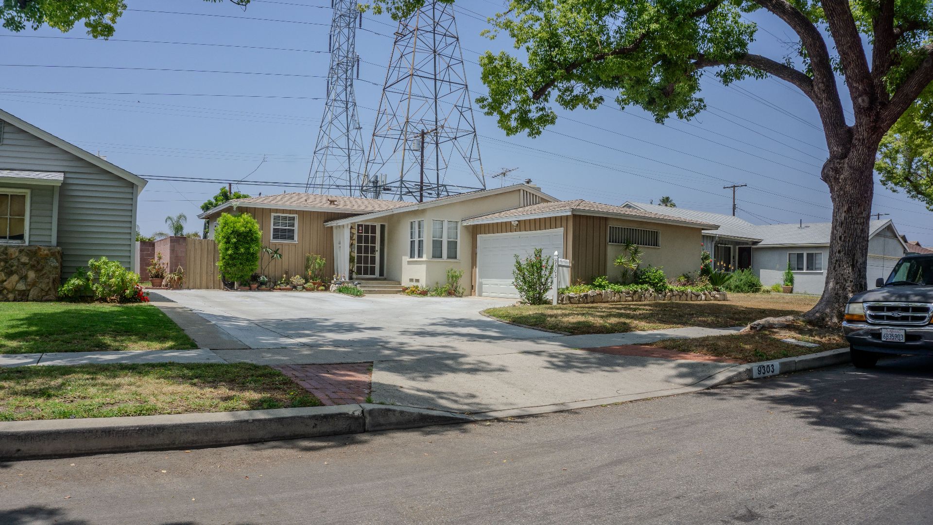Charming suburban street with mid-century homes and lush greenery on a sunny day.