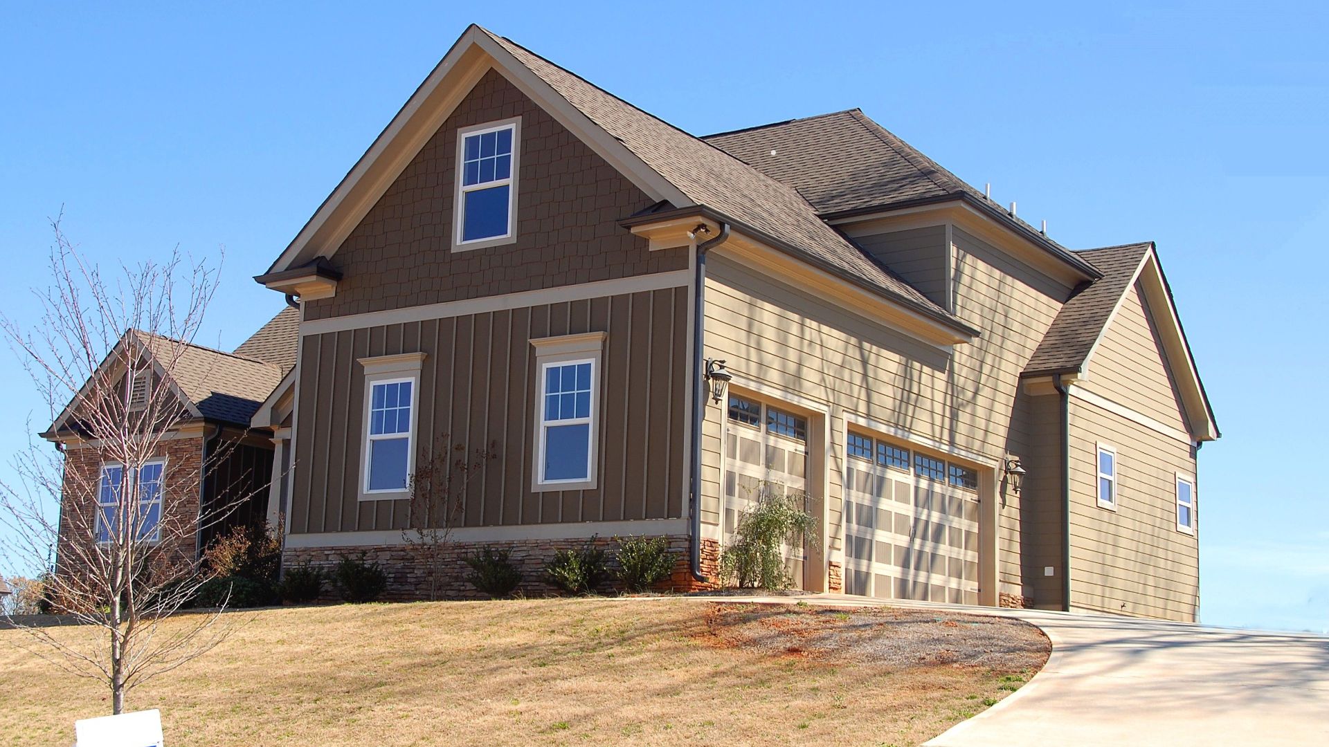 Cozy family home for sale in suburb with spacious garage and landscaped lawn.