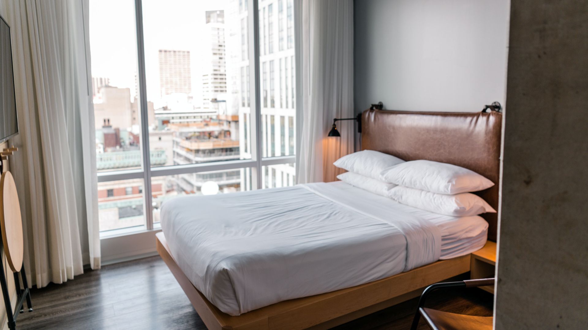Elegant bedroom in a modern Boston apartment with city skyline view.