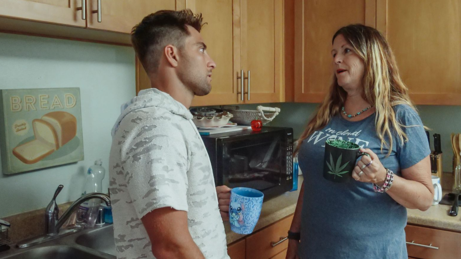 Mother and son enjoying a casual conversation in the kitchen over coffee.
