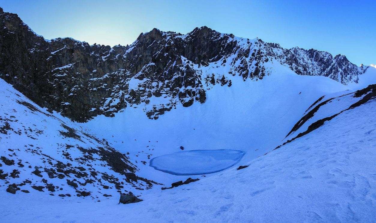 Frozen roopkund lake at sunrise , frozen lake on high altitude .sunrise with high altitude glacial lake .uttarakhand india.