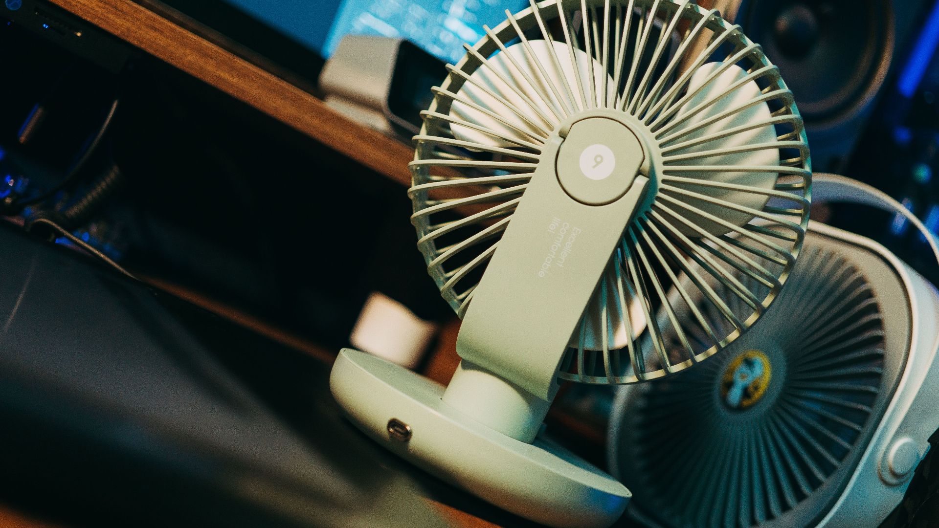 Photo of a desk setup featuring a modern compact fan, emphasizing technology and comfort.