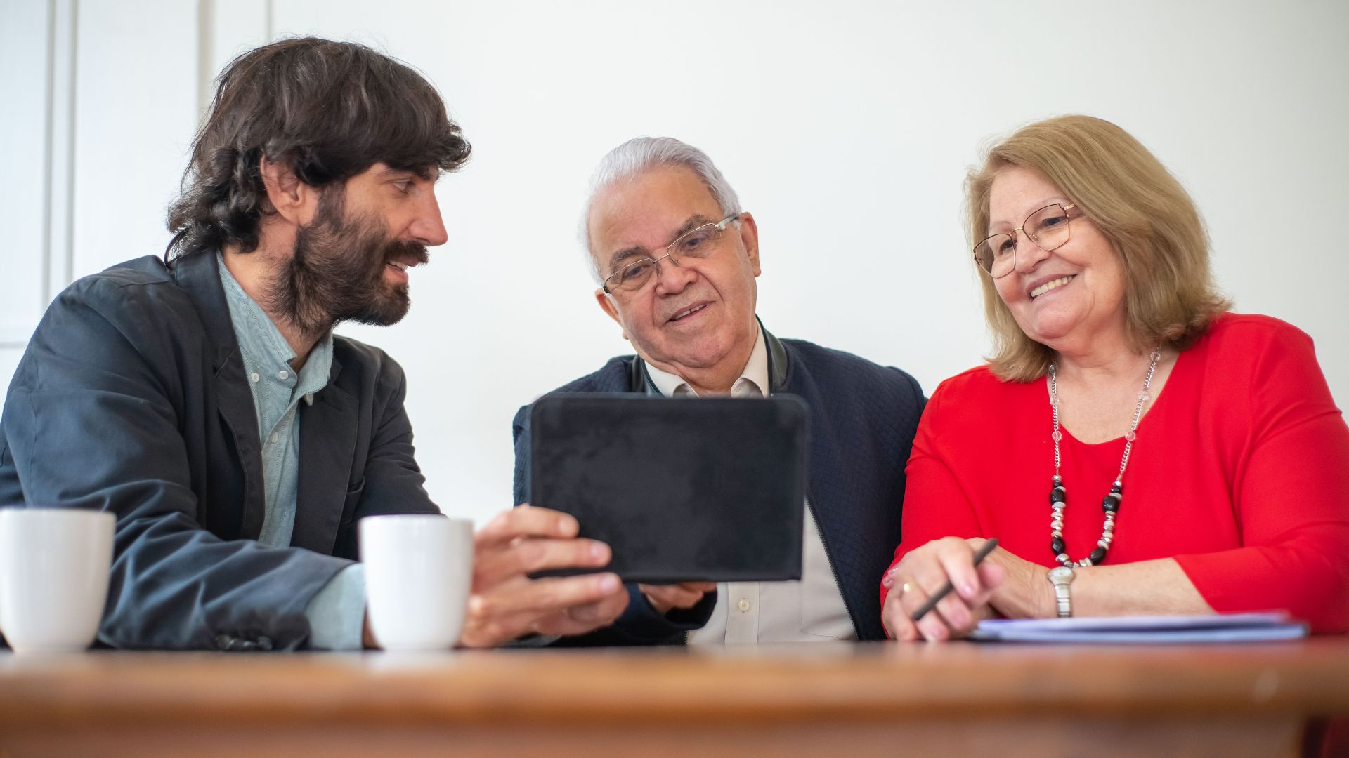 Elderly couple in a meeting with consultant, exploring financial or insurance options.
