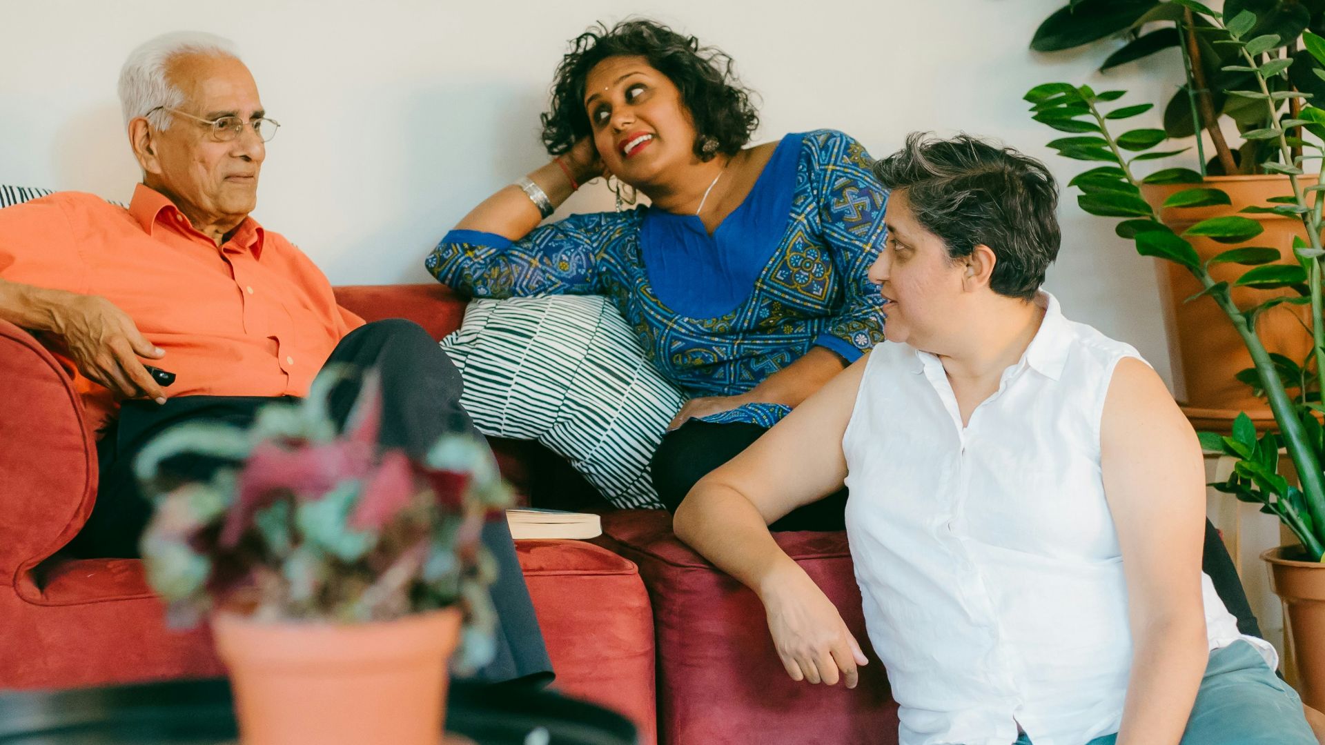 a woman sitting on top of a red couch next to a man