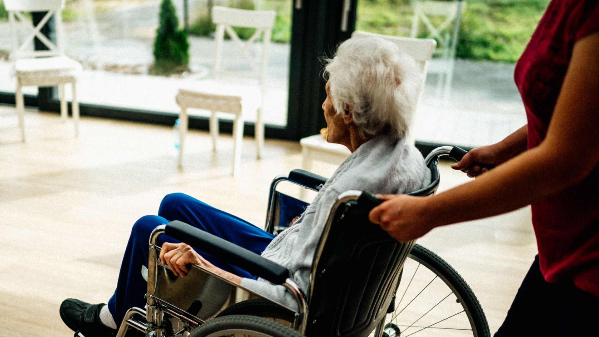 A caregiver assists a senior adult in a wheelchair at a nursing home in Prague, Czech Republic.