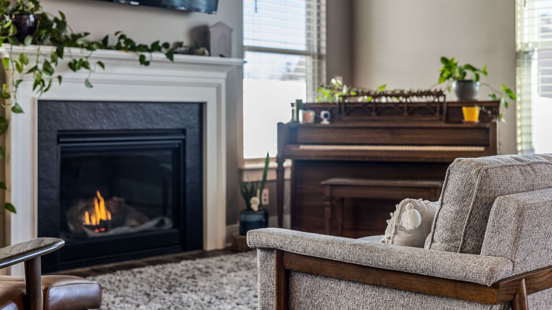 Elegant living room featuring a fireplace and piano, perfect for a relaxing evening indoors.
