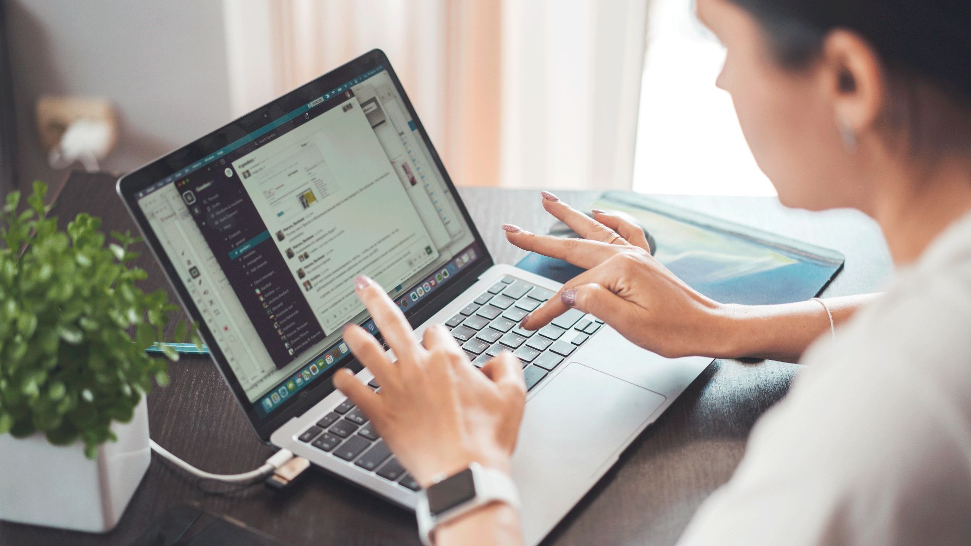 A woman working on a laptop from home, focusing on digital tasks and communication.