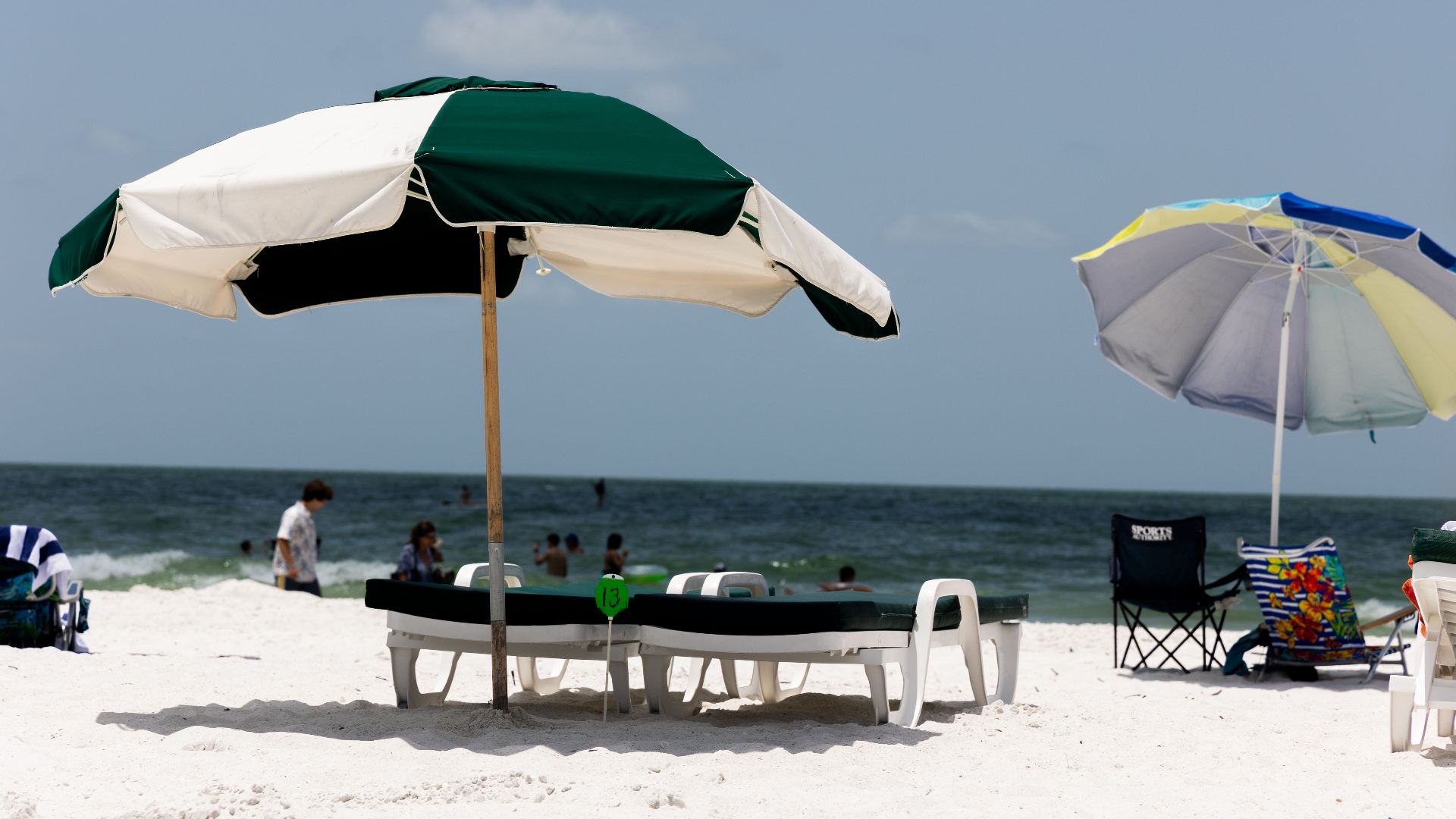 Relaxing beach scene with umbrellas and sunbeds on a sunny, sandy shore.