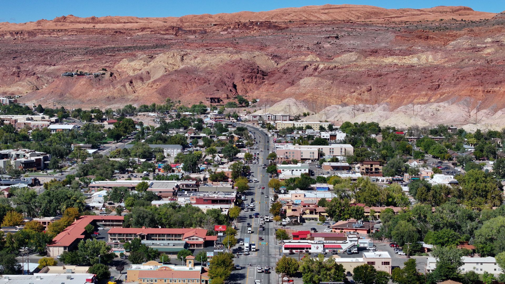 View north along Main Street (U.S. Highway 191) in Moab, Utah, with the downtown below the red rock cliffs and mesas of surrounding canyons.