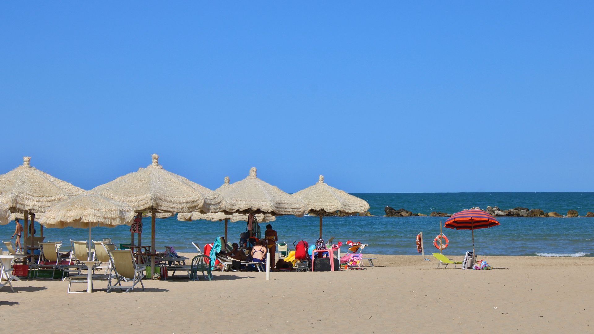 Relax by the sea under umbrellas on Fossacesia beach, Abruzzo, Italy.