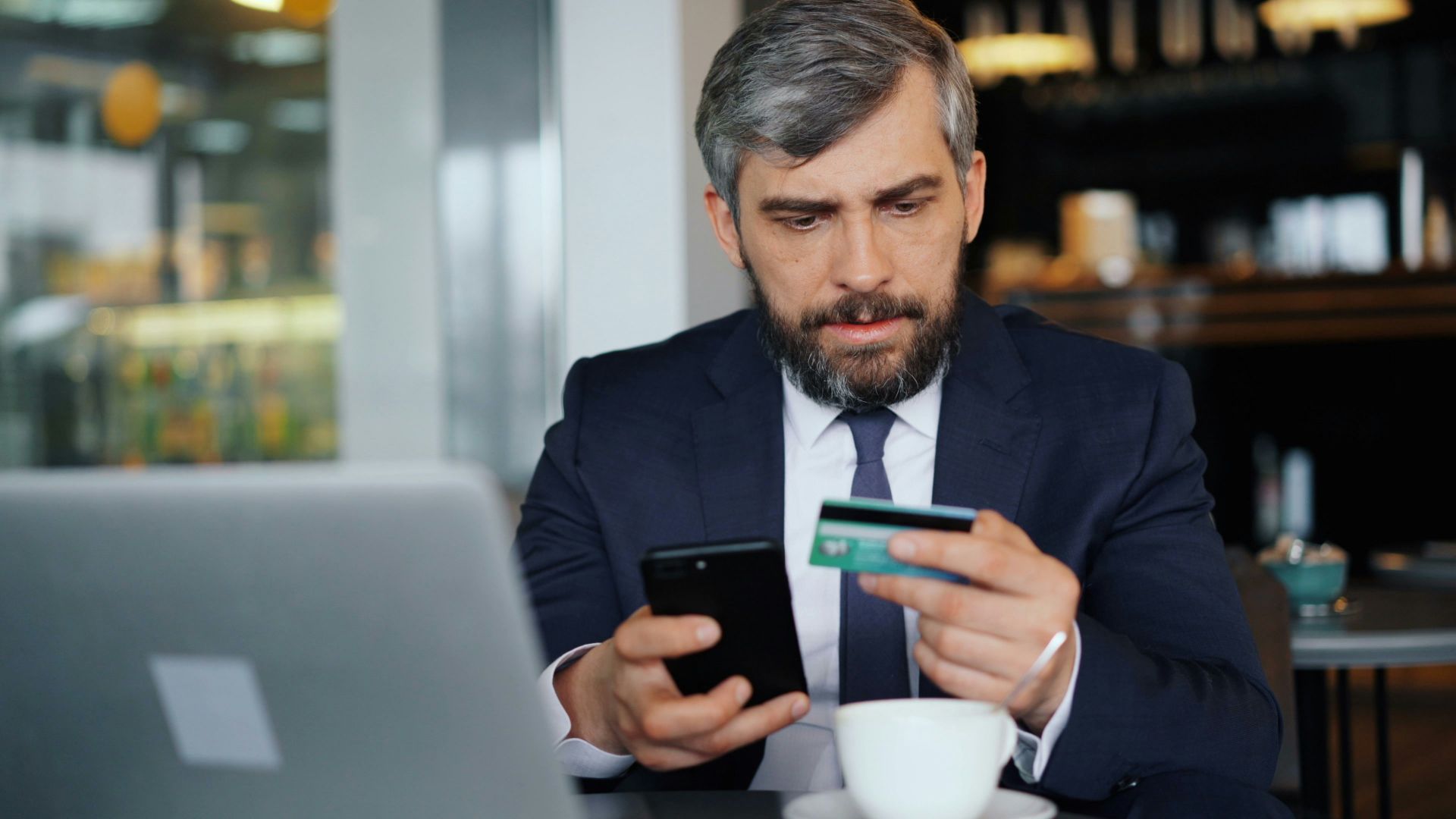 a man sitting at a table looking at his cell phone