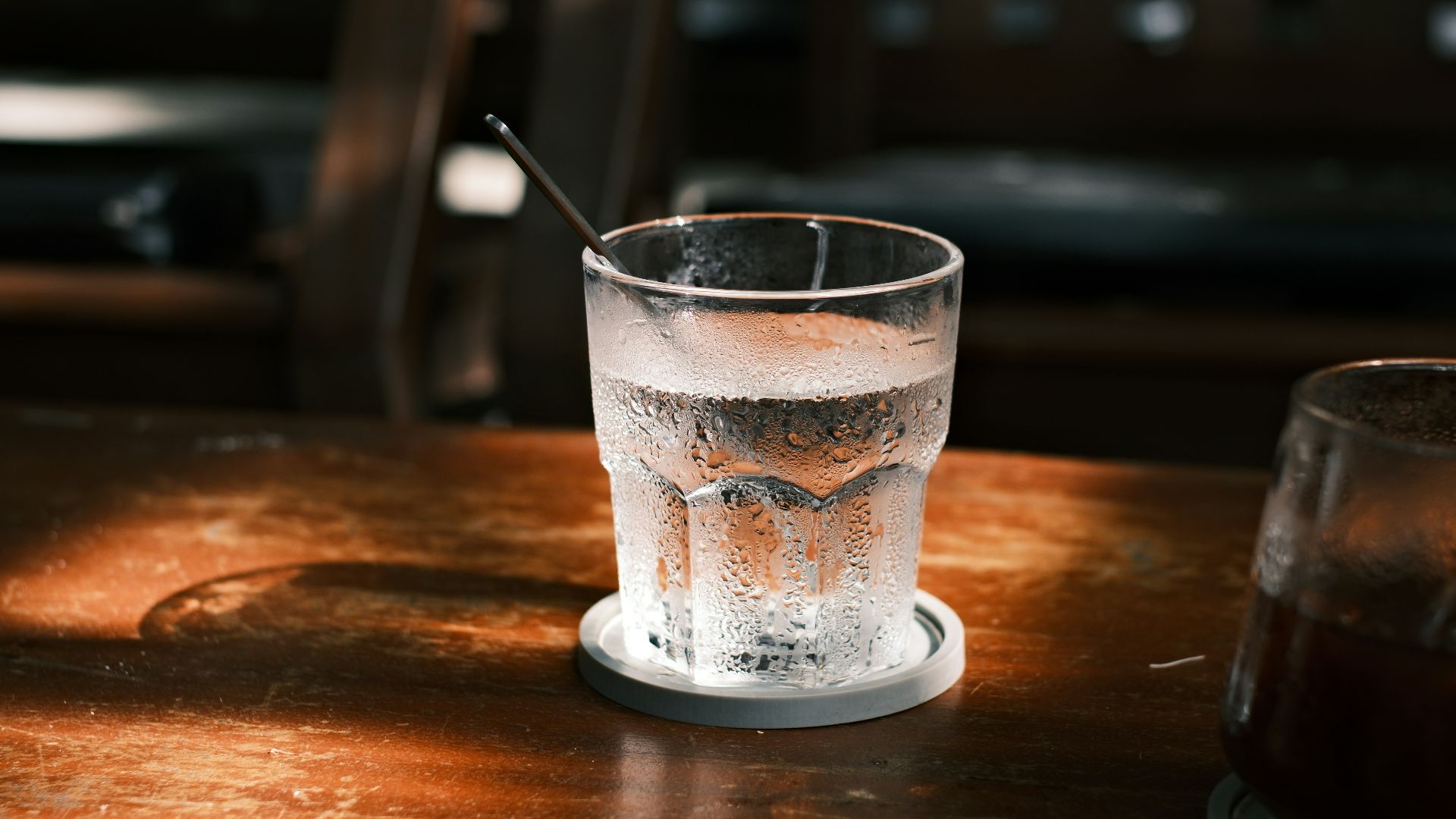 Iced water and dark beverage on a rustic wooden table