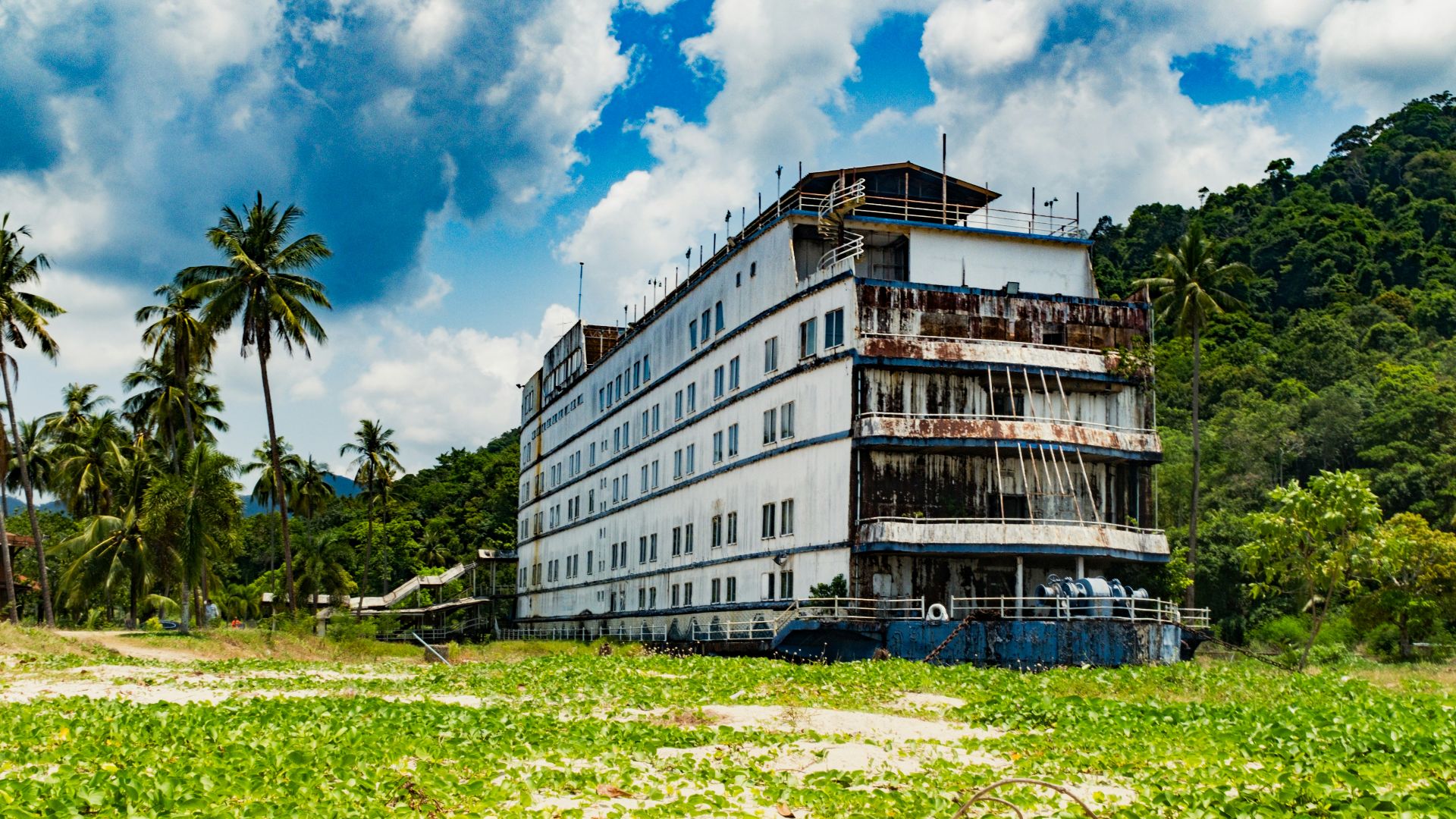 a large white building sitting on top of a lush green field