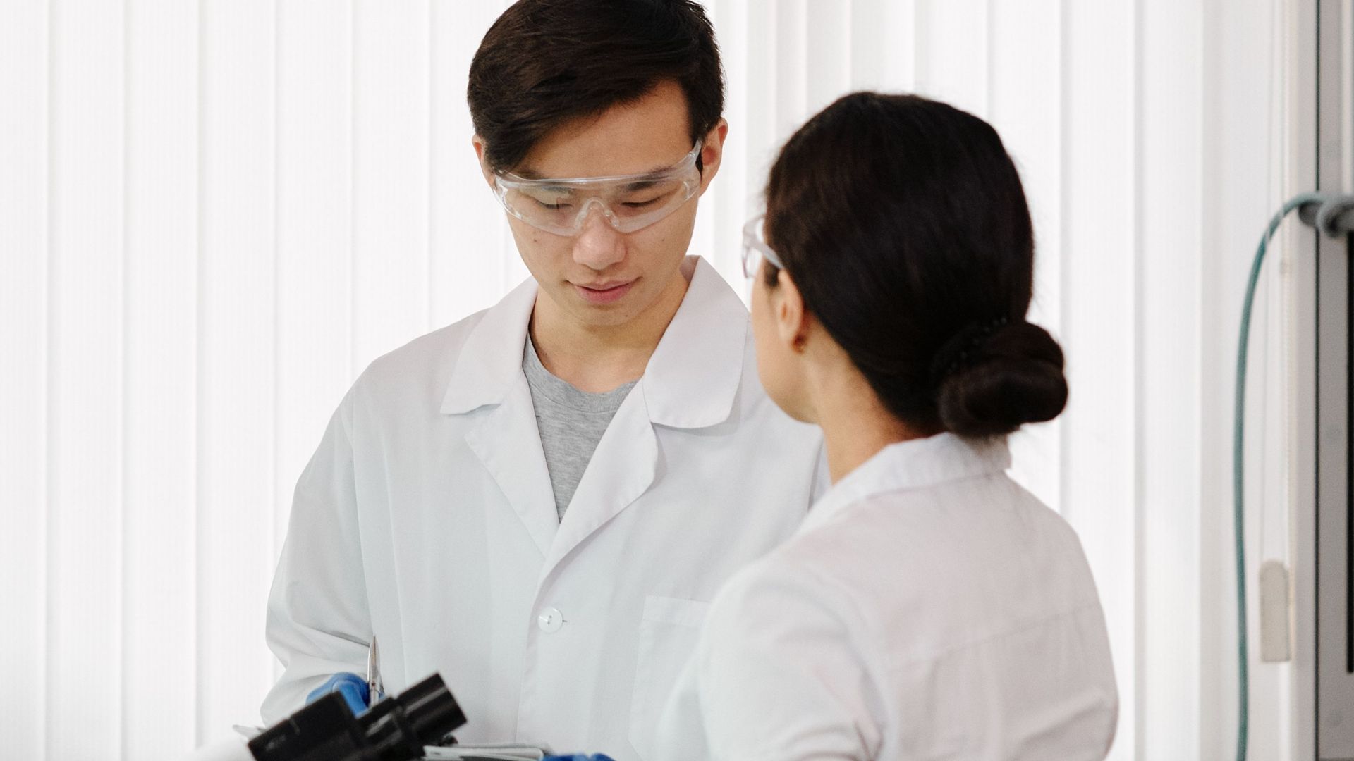 Two scientists in lab coats working in a sophisticated laboratory setting.