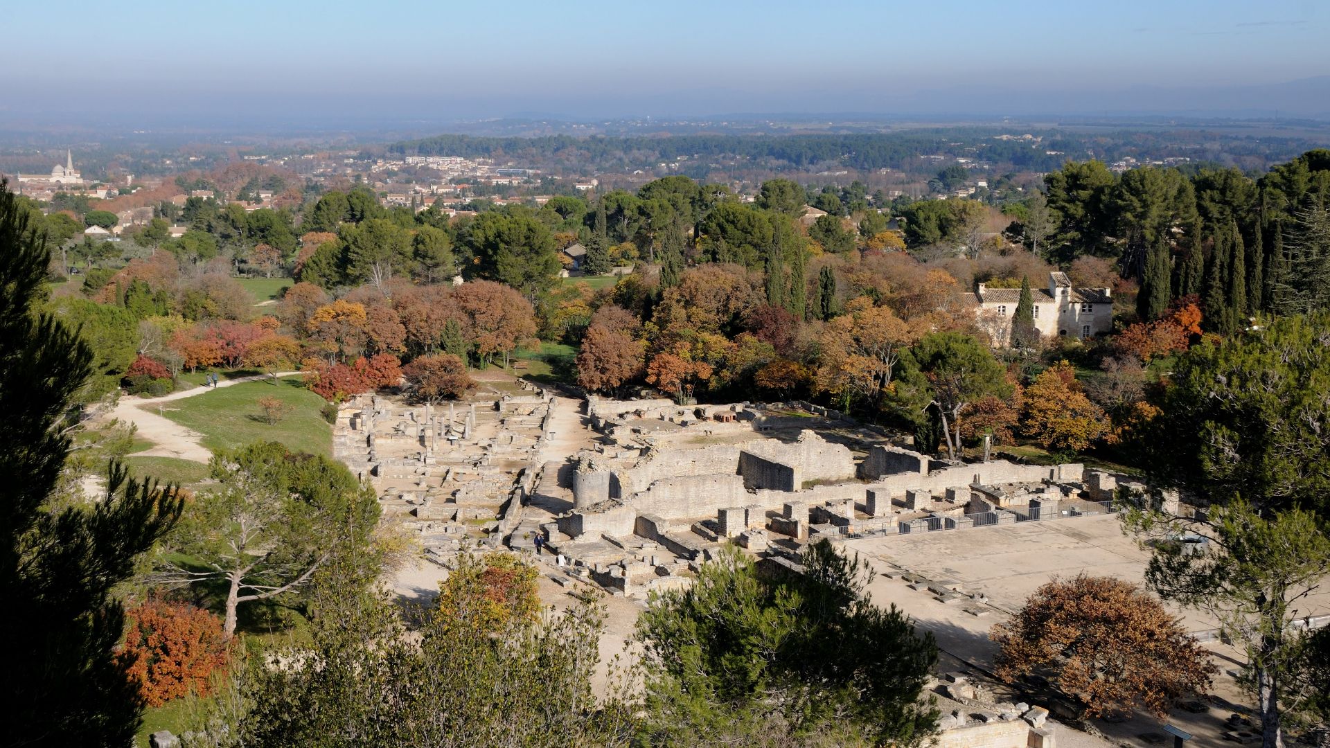 Elevated view of the Glanum archaeological site with Saint-Rémy-de-Provence in the background, France.
