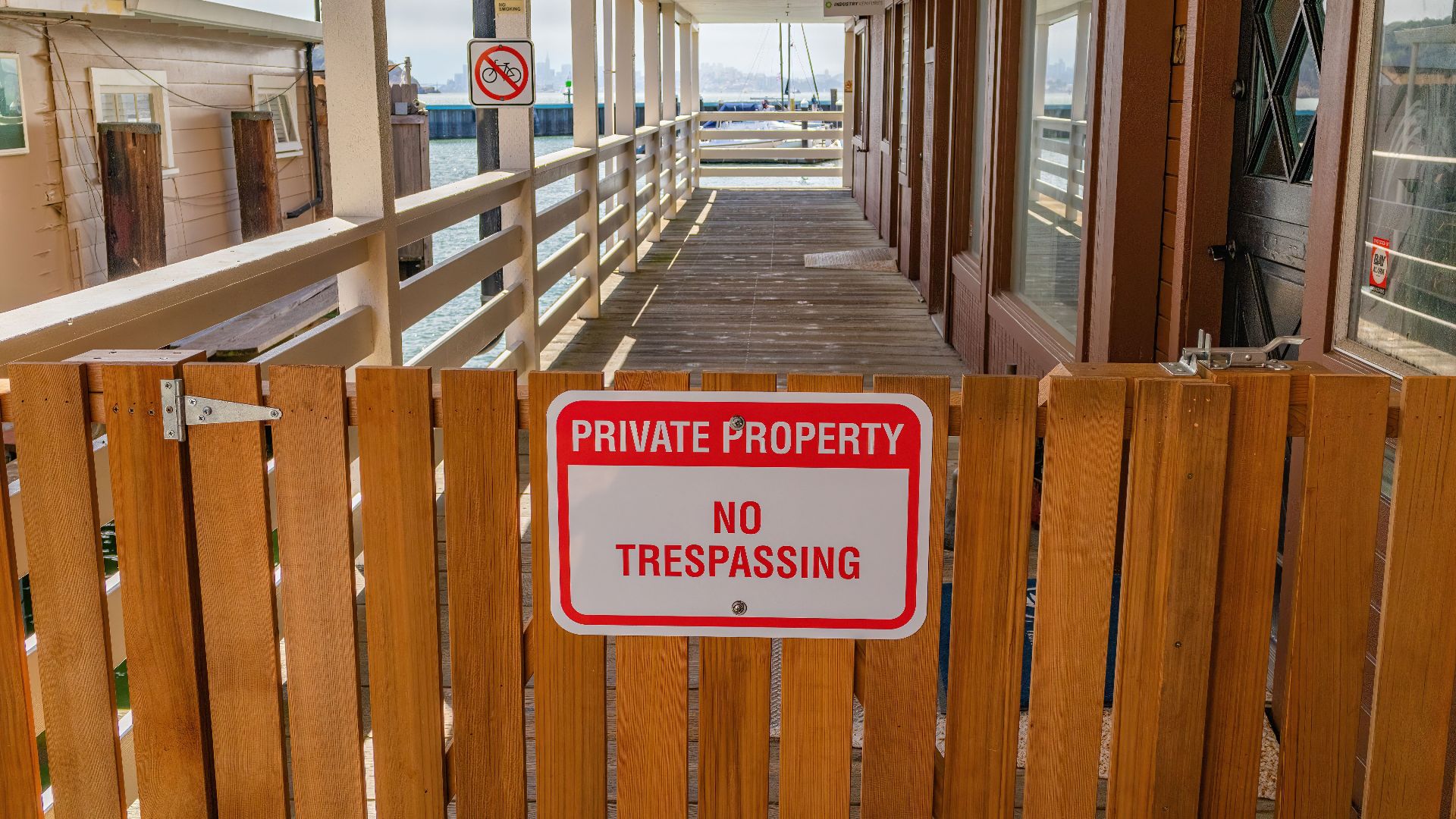 Wooden gate with a private property no trespassing sign in an outdoor setting.