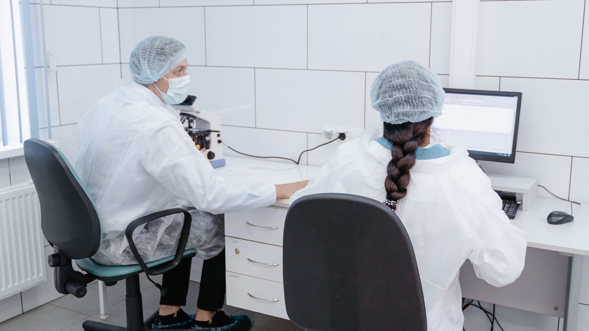 Two scientists working together in a sterile lab environment.
