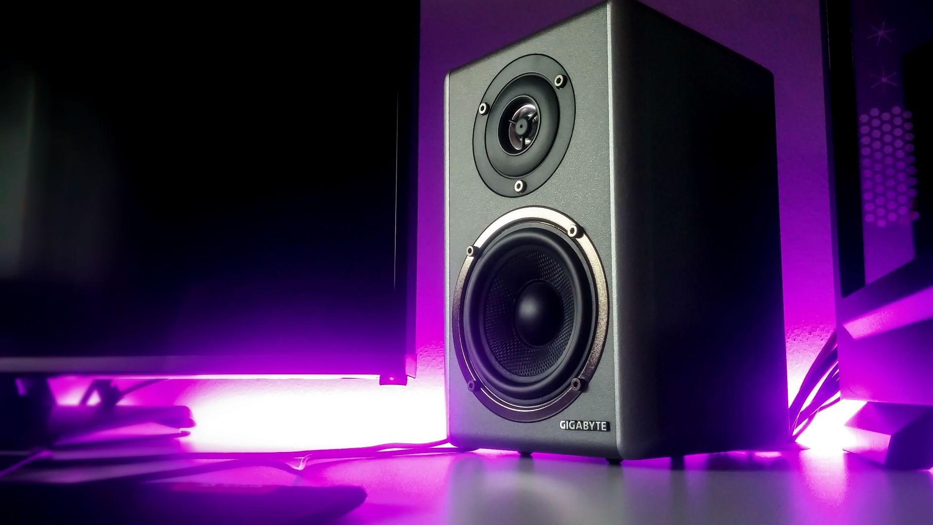 High-quality speaker setup with vibrant purple lighting in a modern studio setting.