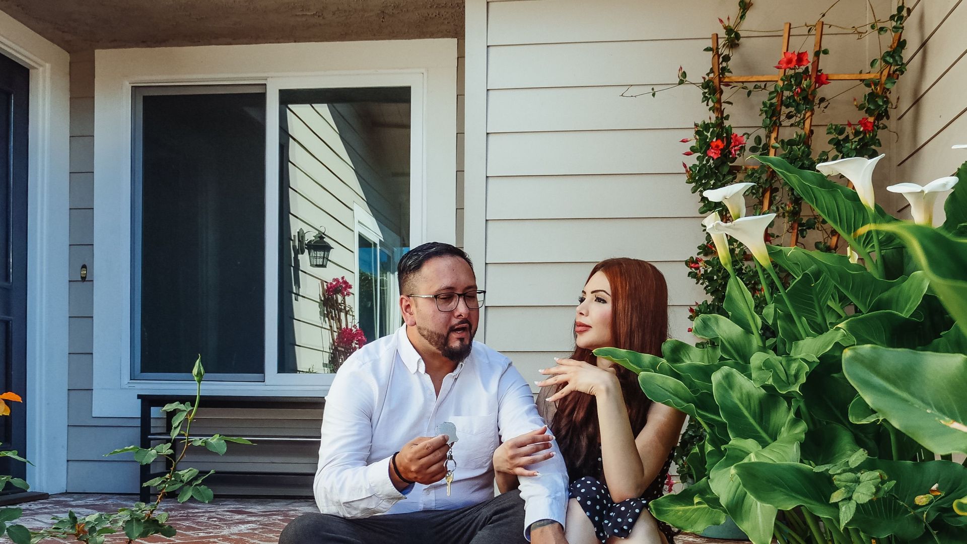 Happy couple enjoying time outside their new home surrounded by lush greenery.