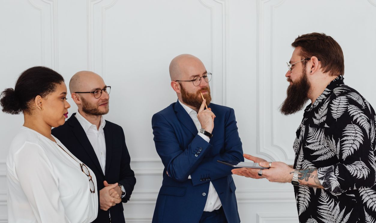 Group of professionals in office discussing documents and ideas 