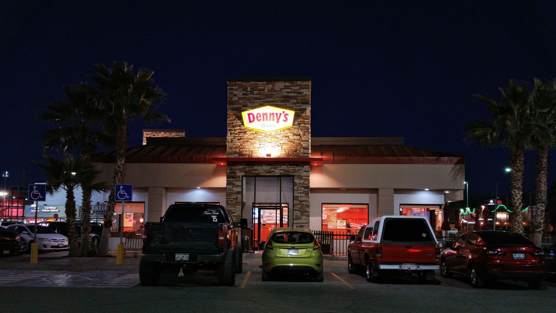 Vista de la fachada de un restaurante Dennys de noche