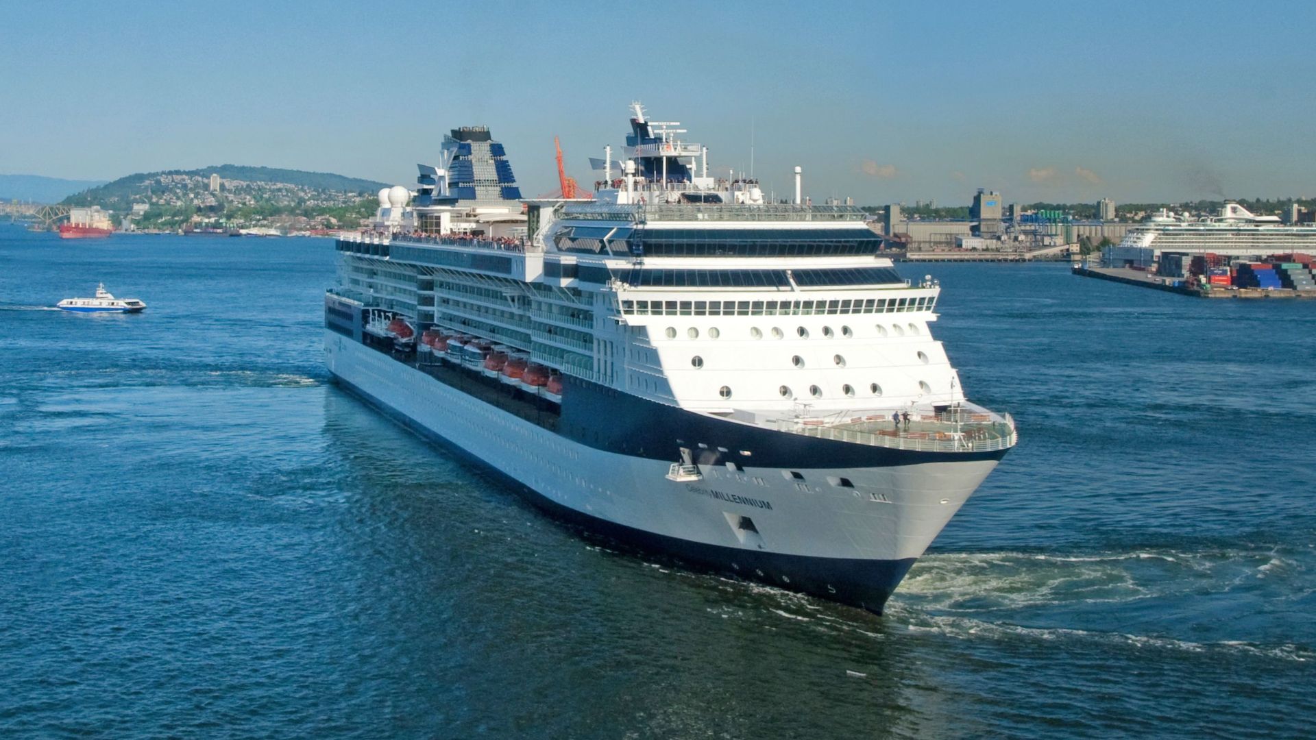 A large cruise ship sailing through calm waters under a clear blue sky, perfect for a relaxing vacation.
