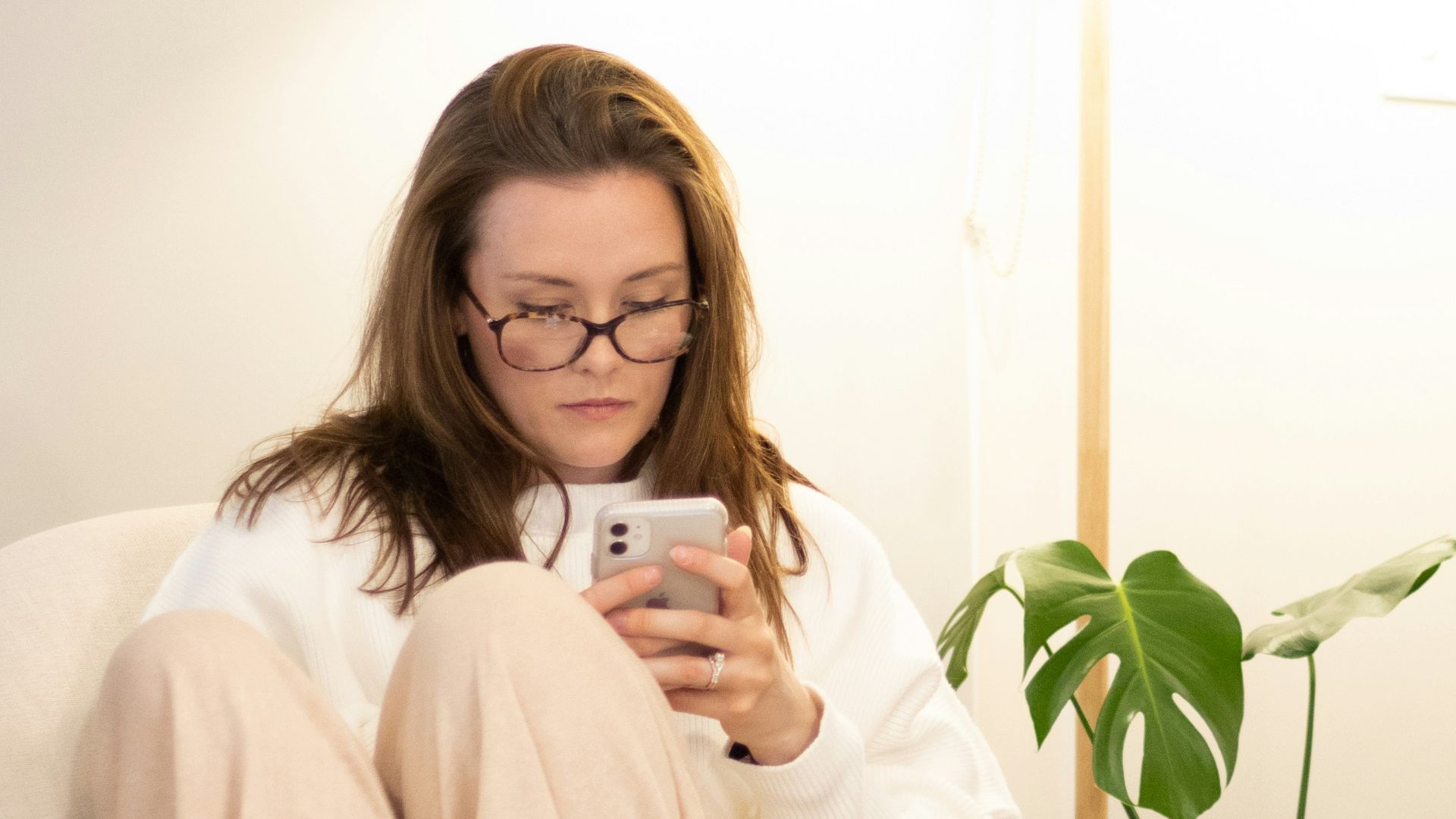 a woman sitting in a chair holding a cell phone