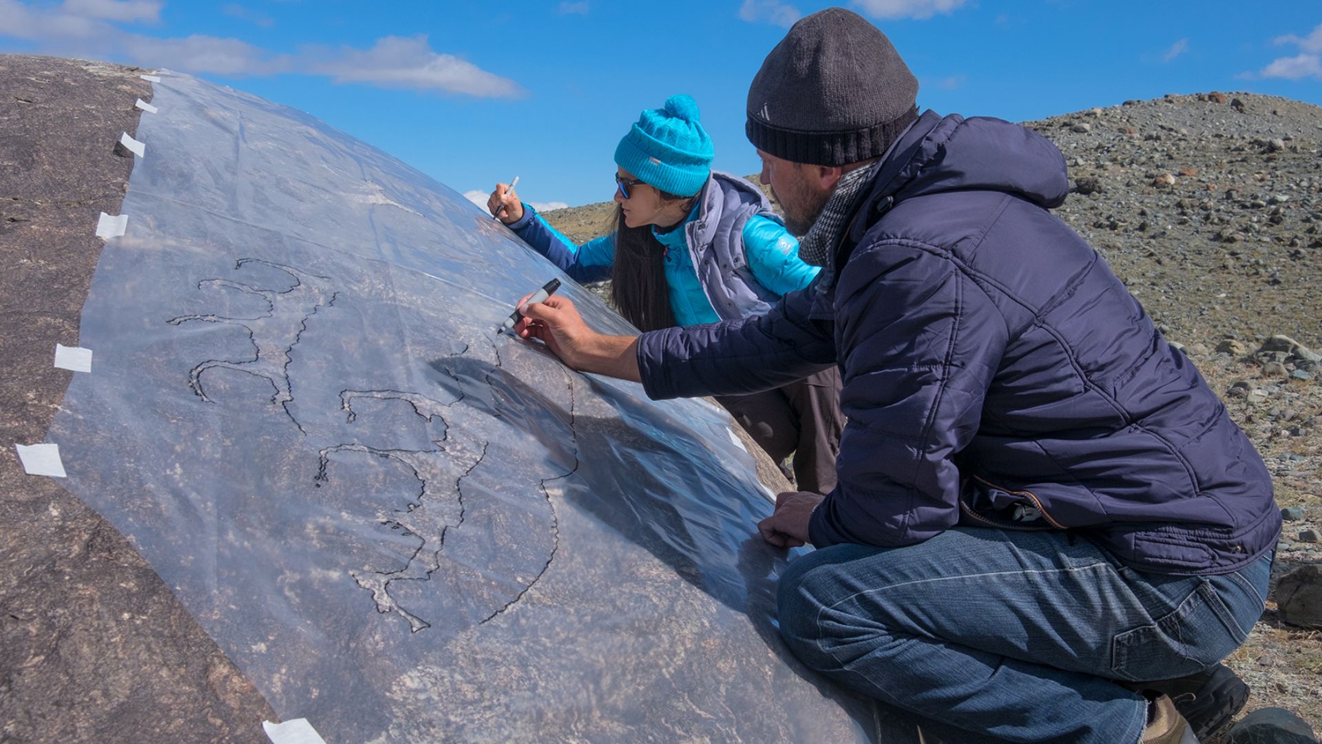 Archaeologists copy the ancient figure in the valley of the Chagan Uzun River in the Altai Mountains
