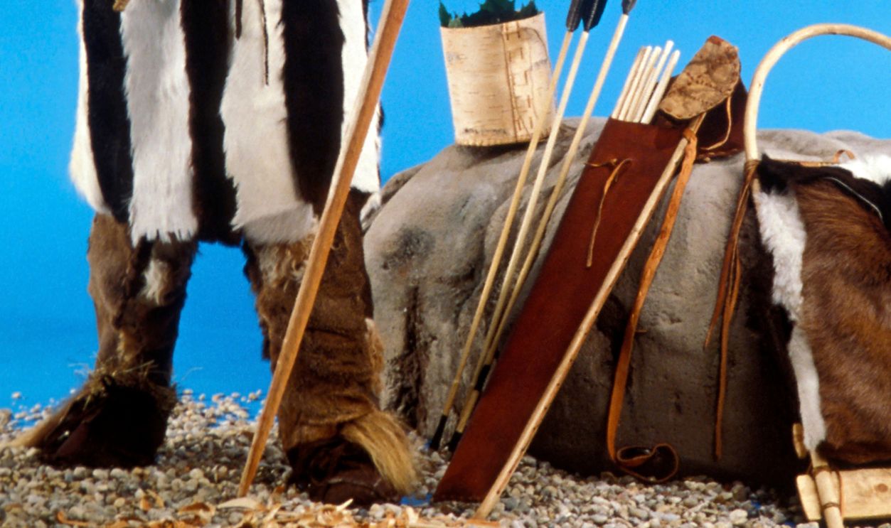 PARIS, FRANCE - OCTOBER 1997: The finished display version of iceman Otzi with a bearskin hat, goatskin coat and leggings, and leather sandals filled with straw on October 1, 1997 in Paris, France. He carried a flint knife in his belt, and is pictured with his bronze axe making a bow out of yew. Otzi is the name given to the frozen mummy of a man from around 3300BC, found by two German tourists in 1991 in the Schnastal glacier in the Oztal Alps.