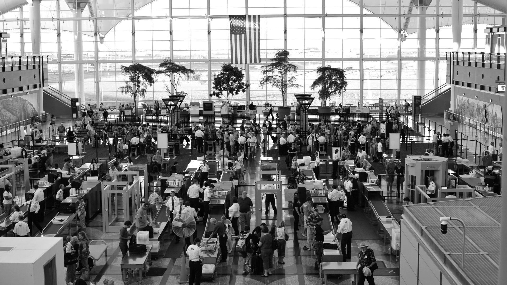 a black and white photo of people in an airport