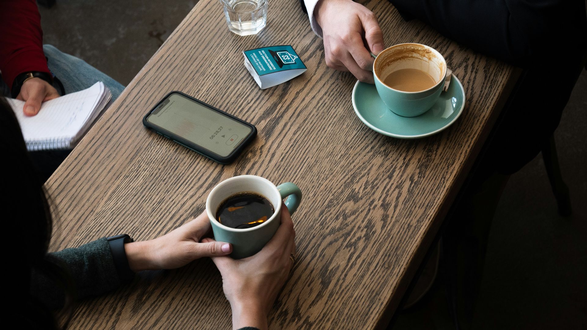 a couple of people sitting at a table with a cup of coffee